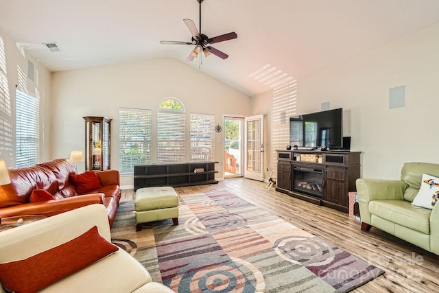 3939 Archer Notch Ln, Huntersville, NC 28078 - living room with light wood-style flooring, ceiling fan, vaulted ceiling, and a glass covered fireplace