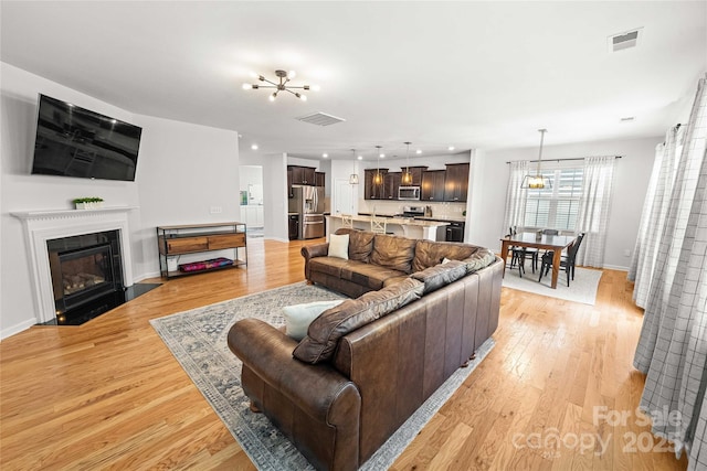 2333 Talon Point Cir, Fort Mill, SC 29715 - living room with a chandelier, light wood finished floors, baseboards, a fireplace with flush hearth, and recessed lighting