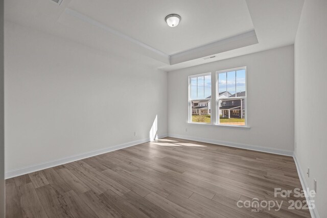 124 Canary Ln Unit 7, Mooresville, NC 28115 - unfurnished room with a tray ceiling, wood finished floors, and baseboards