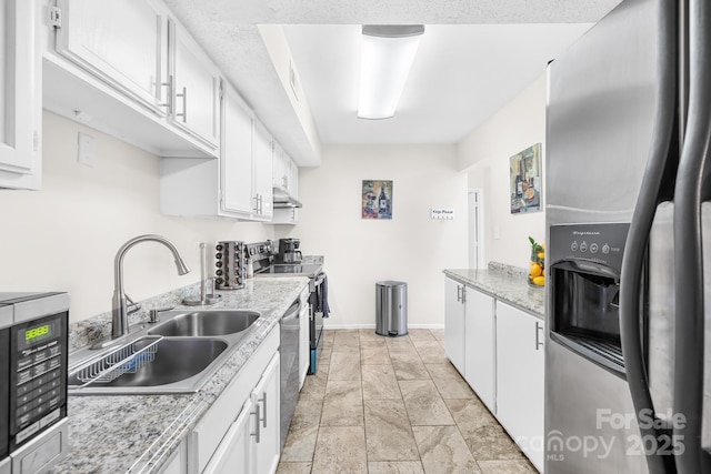 7407 Mystic Ln, Charlotte, NC 28227 - kitchen with under cabinet range hood, appliances with stainless steel finishes, a sink, and white cabinetry