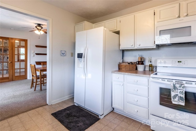 kitchen featuring white appliances, light countertops, a ceiling fan, white cabinetry, and light floors