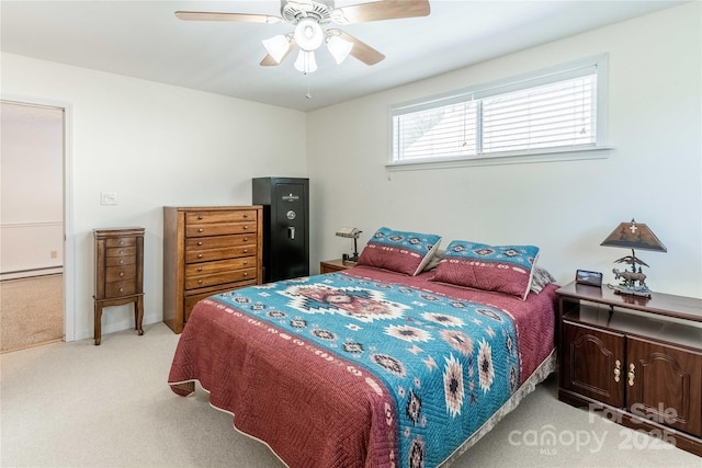 bedroom with light colored carpet, baseboard heating, and ceiling fan