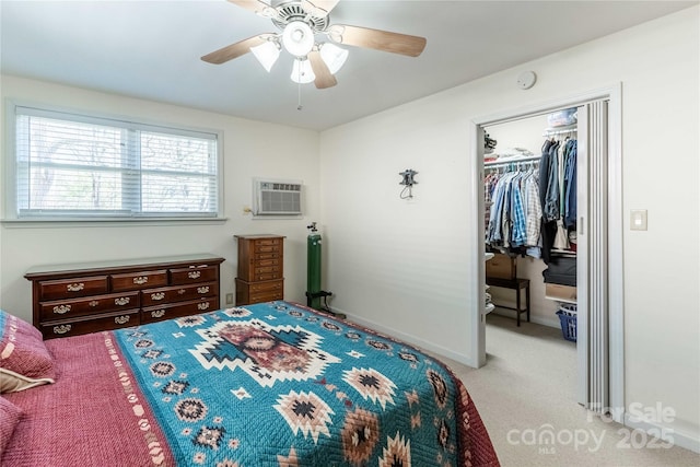 carpeted bedroom featuring a walk in closet, a closet, ceiling fan, a wall mounted AC, and baseboards