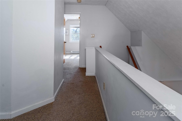 corridor featuring an upstairs landing, vaulted ceiling, baseboard heating, dark colored carpet, and baseboards