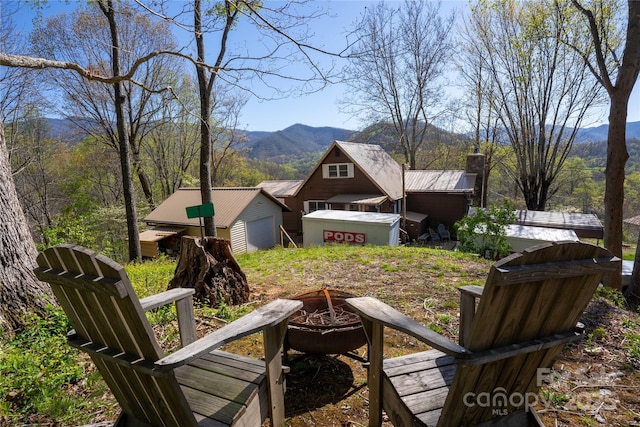 view of yard with a mountain view and an outdoor fire pit