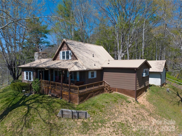 back of house with a chimney, a lawn, and metal roof
