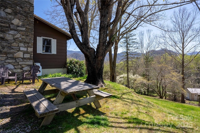 view of green lawn featuring a mountain view