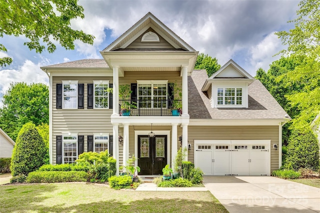 349 Miners Cove Way, Fort Mill, SC 29708 - view of front facade with french doors, a front lawn, concrete driveway, an attached garage, and a balcony