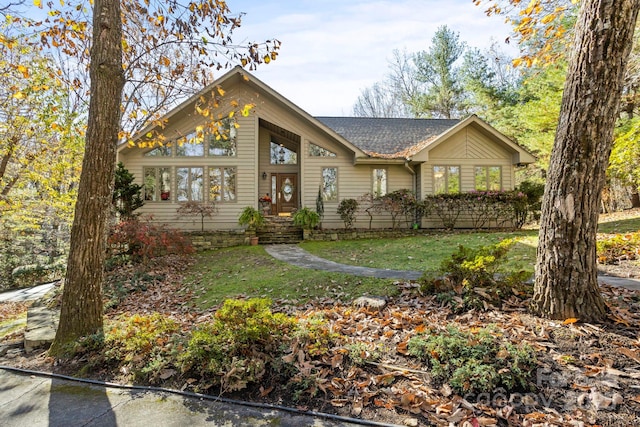view of front of property featuring a shingled roof and a front lawn
