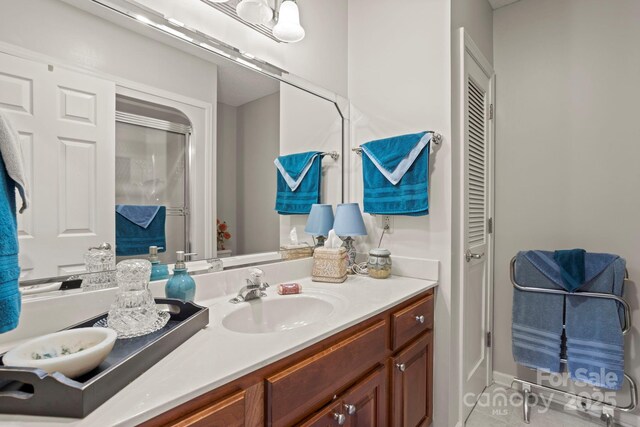 bathroom with tile patterned floors, vanity, and a shower stall