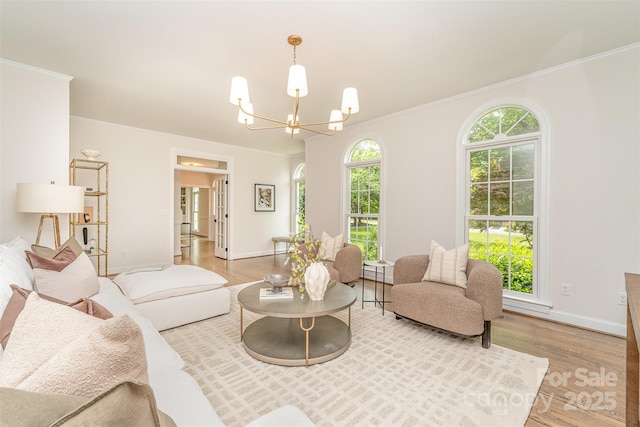 426 Walden Trl, Waxhaw, NC 28173 - living area with an inviting chandelier, ornamental molding, baseboards, and wood finished floors