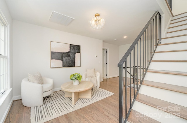 426 Walden Trl, Waxhaw, NC 28173 - living room featuring baseboards, wood finished floors, a notable chandelier, and stairway