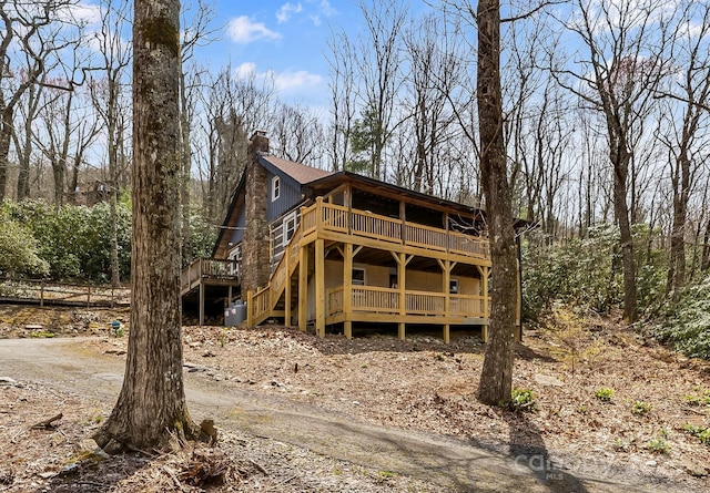 view of property exterior featuring a chimney and a wooden deck