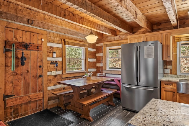 dining space featuring beamed ceiling, dark wood-type flooring, wood walls, and wood ceiling