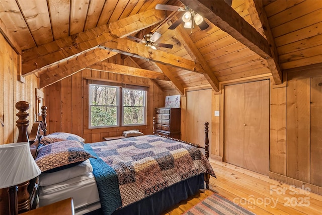 bedroom with wood ceiling, lofted ceiling with beams, wood walls, and light wood-style floors