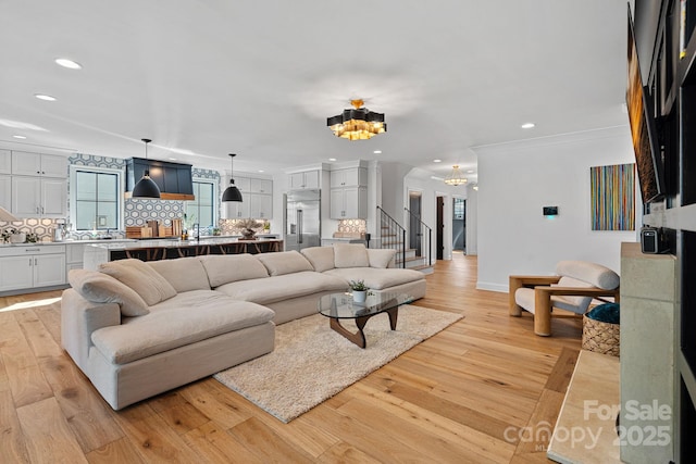 living room with light wood-style flooring, recessed lighting, and a notable chandelier