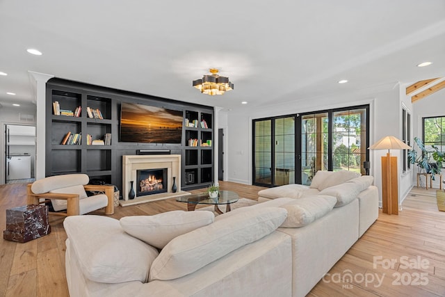 living room with wood finished floors, recessed lighting, and a lit fireplace