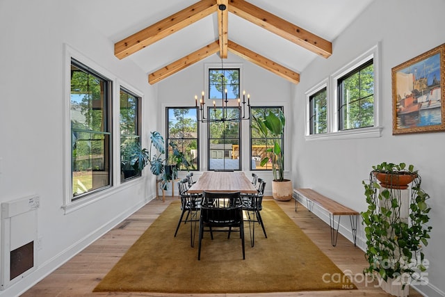 dining space with an inviting chandelier, beam ceiling, and light wood finished floors