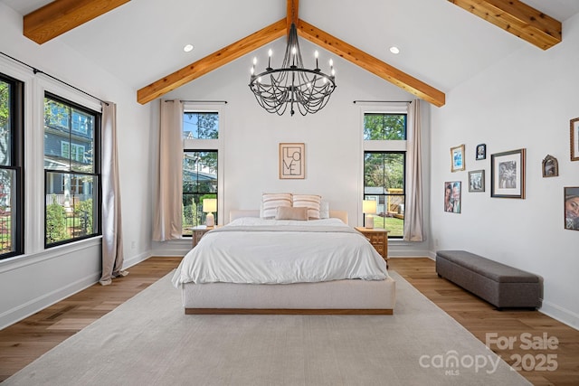 bedroom featuring beamed ceiling, wood finished floors, recessed lighting, and a notable chandelier