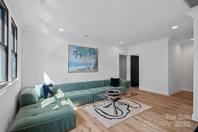 living room with visible vents, baseboards, recessed lighting, wood finished floors, and ornamental molding