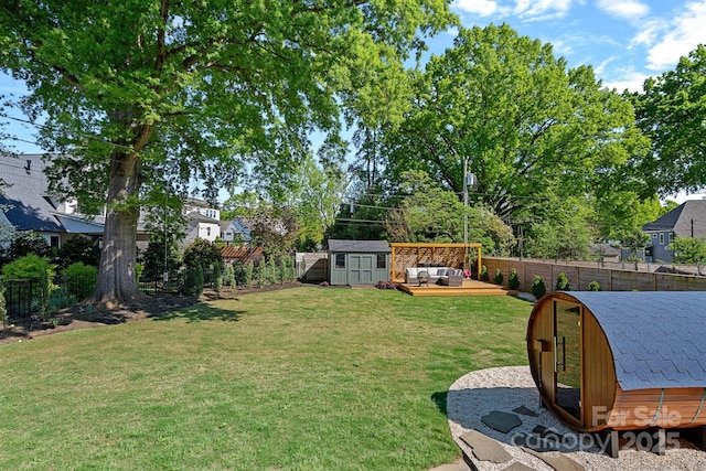 view of yard with a storage unit, an outbuilding, a fenced backyard, and an outdoor living space
