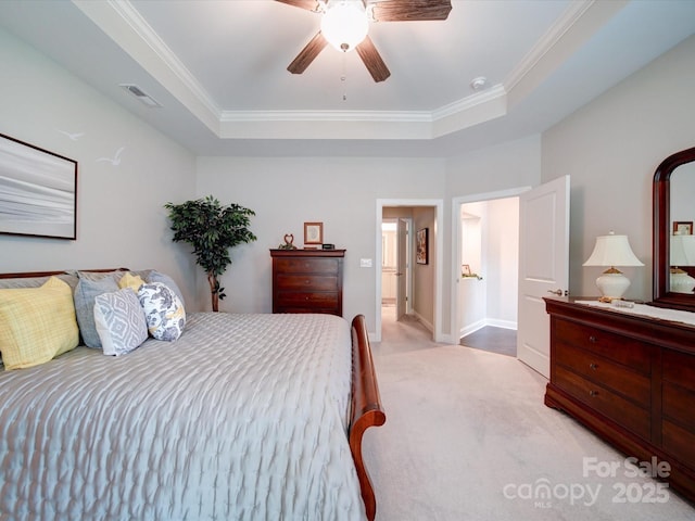 bedroom featuring a tray ceiling, visible vents, a ceiling fan, ornamental molding, and light carpet