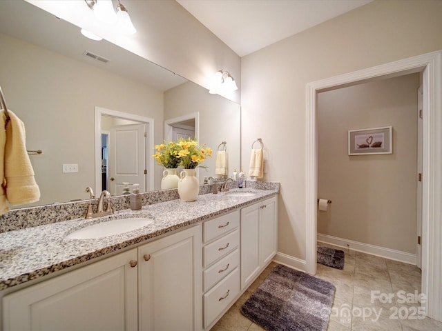 bathroom featuring double vanity, visible vents, baseboards, and a sink