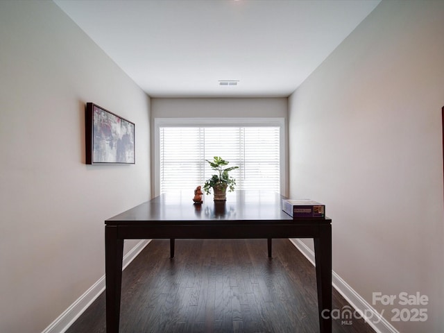 office space featuring baseboards, visible vents, and dark wood-type flooring