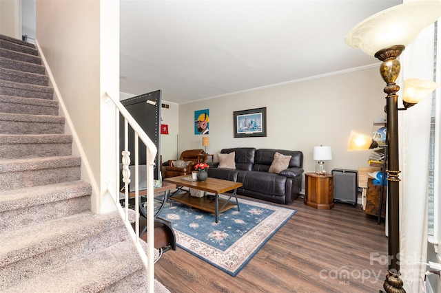 living room with crown molding, wood finished floors, and stairs