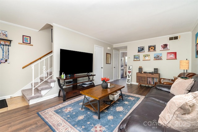 living area featuring stairway, wood finished floors, visible vents, and ornamental molding
