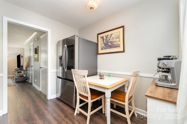 dining area with baseboards and dark wood-style flooring