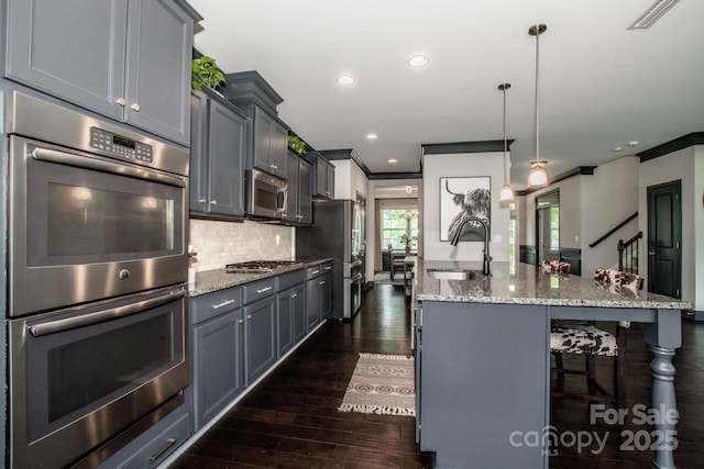 10707 Charmont Pl, Huntersville, NC 28078 - kitchen featuring a sink, stainless steel appliances, a kitchen island with sink, dark wood-type flooring, and light stone countertops