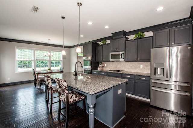 10707 Charmont Pl, Huntersville, NC 28078 - kitchen with stainless steel appliances, ornamental molding, a kitchen island with sink, a kitchen breakfast bar, and backsplash