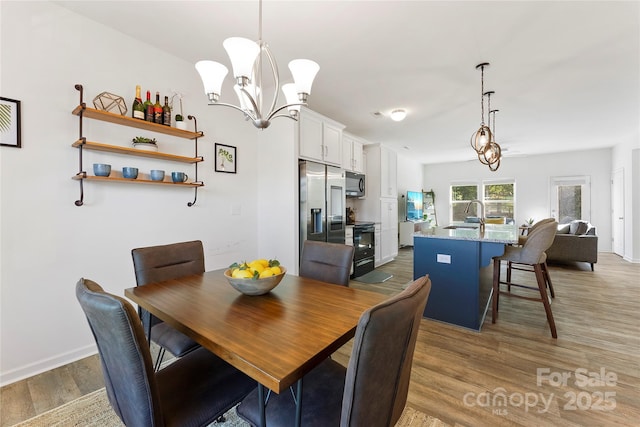 548 Dutch White Dr, Clover, SC 29710 - dining space with wood finished floors, a chandelier, and baseboards