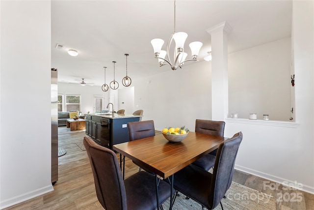 548 Dutch White Dr, Clover, SC 29710 - dining area with light wood-style flooring, a ceiling fan, a chandelier, and baseboards