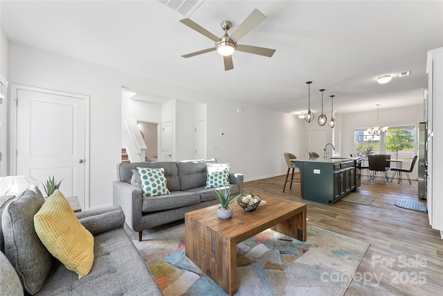 548 Dutch White Dr, Clover, SC 29710 - living area featuring ceiling fan, wood finished floors, a chandelier, stairs, and baseboards