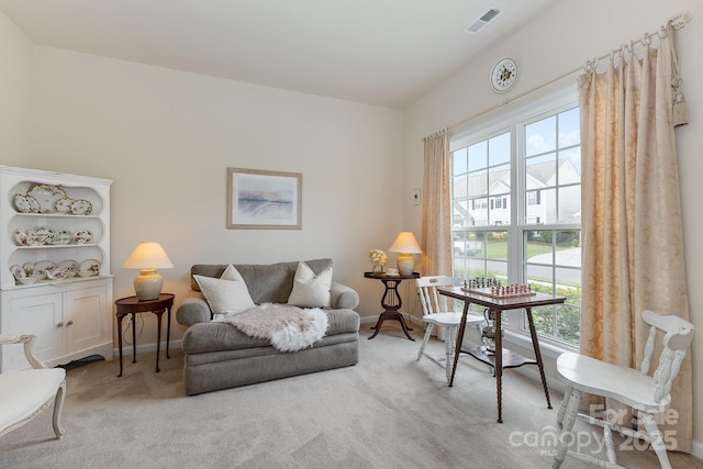living area with carpet floors, baseboards, and visible vents