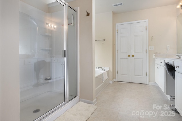 full bath featuring visible vents, baseboards, a garden tub, and a shower stall