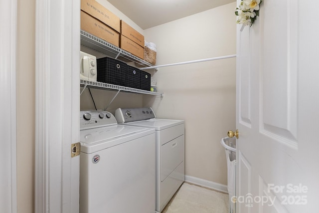 clothes washing area featuring baseboards, laundry area, and independent washer and dryer