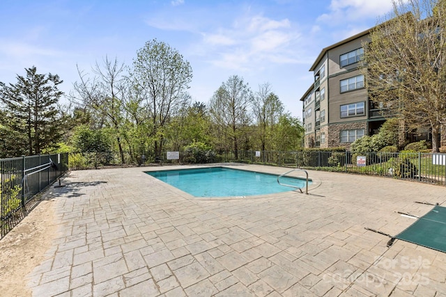 community pool with fence and a patio area