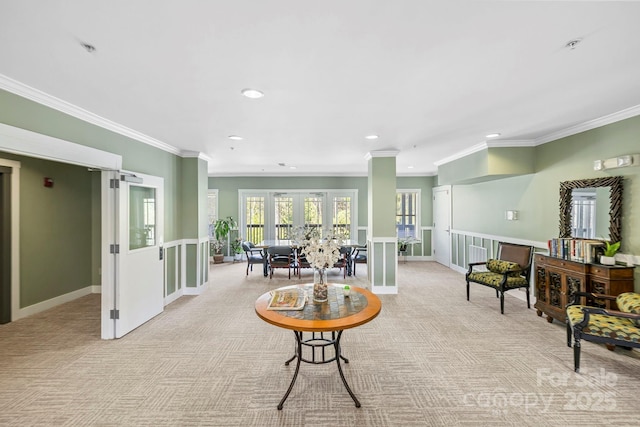living area with baseboards, light colored carpet, and ornamental molding