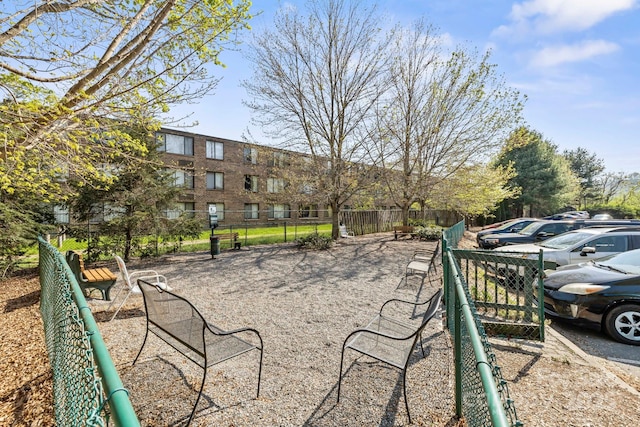view of community featuring uncovered parking and fence