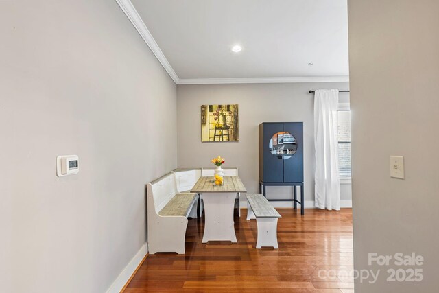 dining space featuring baseboards, ornamental molding, wood finished floors, and recessed lighting