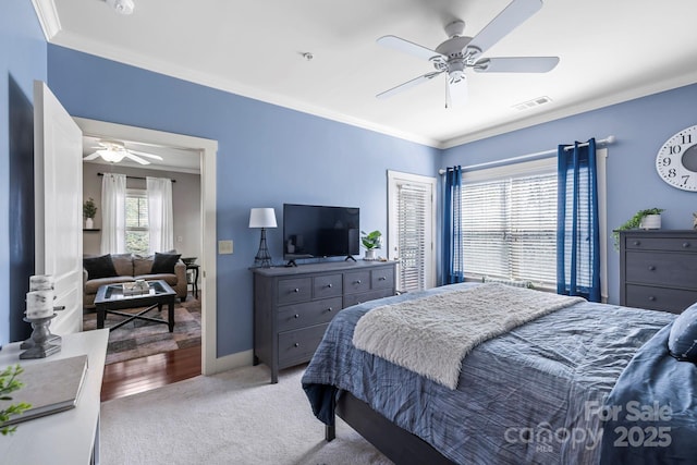bedroom featuring carpet floors, visible vents, crown molding, and a ceiling fan