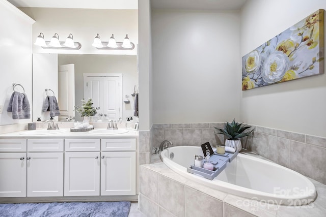 full bath with a bath, double vanity, and a sink