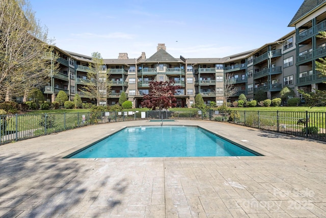 community pool featuring a patio area and fence