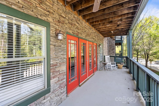 exterior space with stone siding, french doors, and covered porch