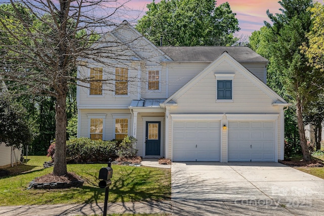 traditional-style home with a garage, driveway, and a front yard