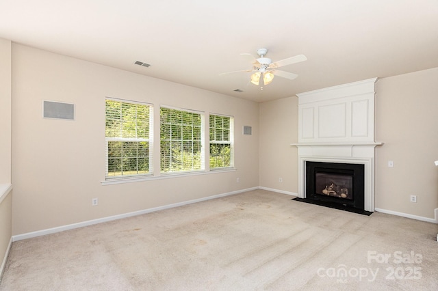 unfurnished living room featuring light carpet, a ceiling fan, visible vents, and a large fireplace