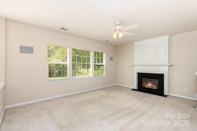 unfurnished living room with visible vents, a ceiling fan, light carpet, baseboards, and a fireplace